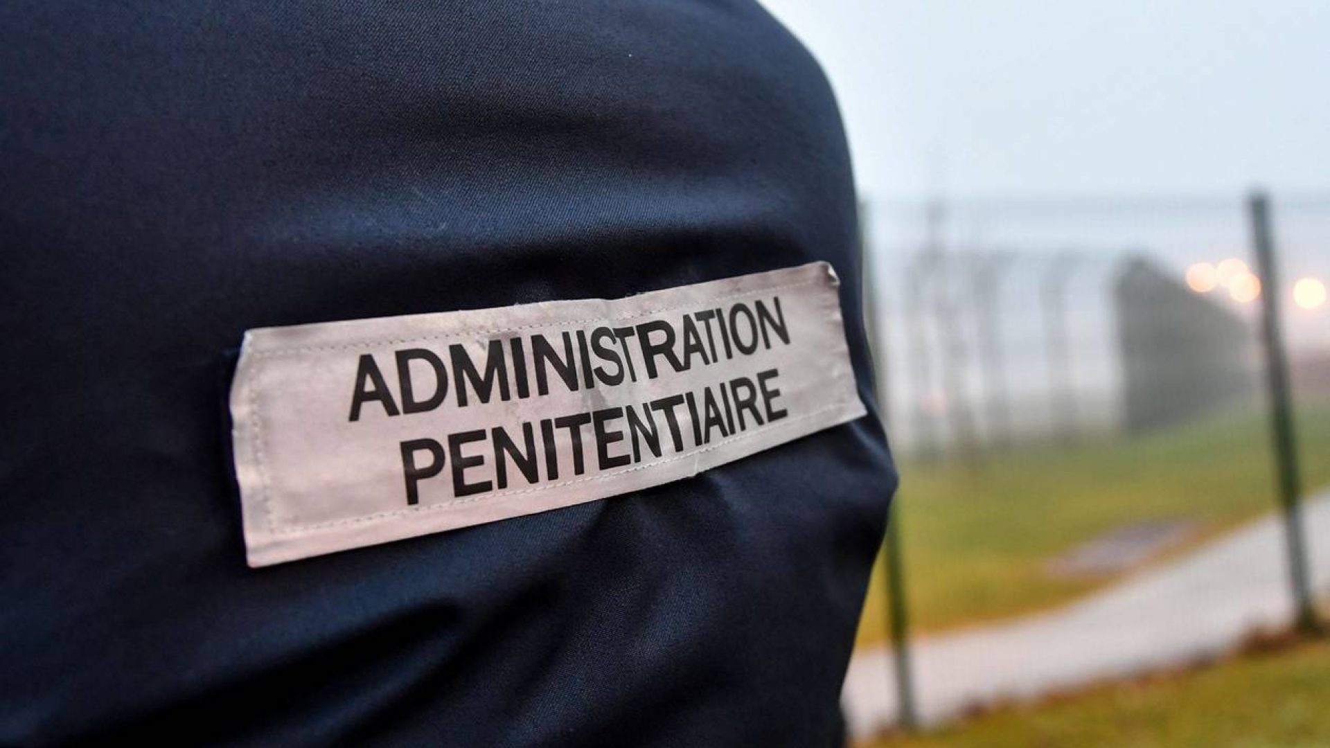 The penitentiaty administration tag is pictured on a warden's jacket as prison wardens gather outside the high-security prison of Vendin-le-Vieil, northern France, on January 12, 2018, a day after three prison guards have been injured in a blade attack by a German Al-Qaeda militant. Islamic convert Christian Ganczarski, serving an 18-year sentence over the 2002 blast in Djerba that killed 21 people, launched himself at prison officers after hearing he may face extradition to the US in connection with 9/11 investigations, according to union sources. / AFP / Denis Charlet